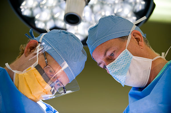 Lance Hampton performing surgery with resident Corey Johnson